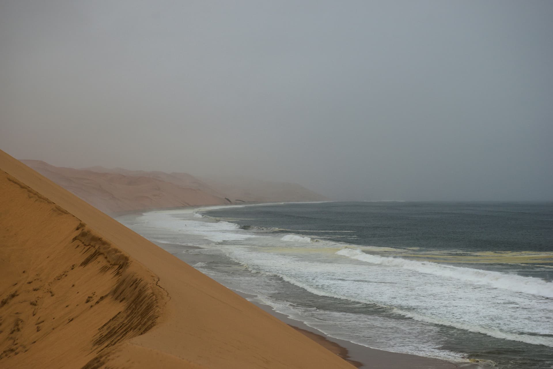 Sandwich Harbour dunes dropping straight into the Atlantic surf.